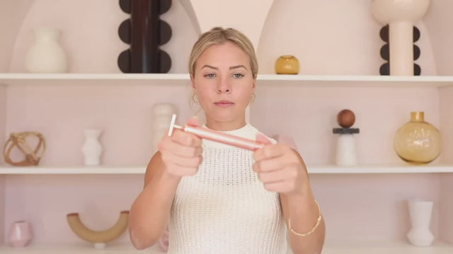 A woman using the massage bar to contour her jawline.
 امرأة تستخدم أداة التدليك لنحت خط فكها.